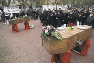  ?? Pascal Pochard-Casabianca / AFP via Getty Images ?? Protesters in Bastia on the French island of Corsica gather Thursday around coffins representi­ng the suffering of restaurant workers during the shutdown of cafes and bars amid the virus resurgence.