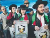  ?? Ahmad Gharabli, AFP ?? Members of Neturei Karta, a small faction of anti-Zionist ultra-Orthodox Jews who oppose Israel’s existence, hold pictures ofMohammad Abu Khieder in eastern Jerusalem.