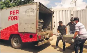  ?? THE ASSOCIATED PRESS ?? Forensic officers load the body of a victim killed in one of two attempted bank heists in Milagres in Brazil's state of Ceara on Friday.