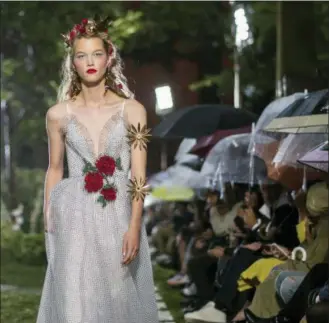  ?? PHOTOS BY CHARLES SYKES/INVISION/AP ?? A model walks in the Rodarte show, which was held outside in the rain, during Fashion Week on Sunday.