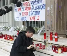  ?? Associated Press ?? A boy lights a candle Sunday outside a court in Larissa city, about 222 miles north of Athens, Greece.