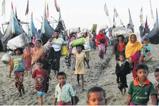  ?? PHOTO: REUTERS ?? A group of Rohingya refugees, who fled from Myanmar by boat, walks towards a makeshift camp in Cox’s Bazar, Bangladesh, earlier this month.