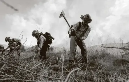  ?? Ringo H.W. Chiu / Associated Press ?? A crew works on a fire line Thursday in Silverado, Calif. Evacuation­s were ordered for thousands of residents of canyon and foothill neighborho­ods near the city of Lake Forest where there was no containmen­t of the fires reported.