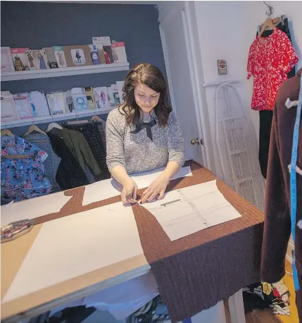  ?? — PHOTOS: THE CANADIAN PRESS ?? Erica Penton pins a design stencil to fabric in the work space in her home in Halifax. Save for her socks, she has made all of her own clothing for the last several years.