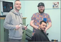 ??  ?? David Mitchell and Steven Thompson cut a client’s hair at the Homeless Barbers