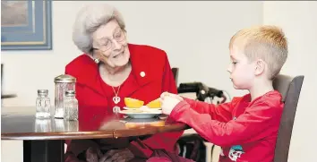  ?? TROY FLEECE ?? Miriam Wheeler, left, and Colton Ahlquist sit together while Colton has a snack at Orange Tree Living developmen­t in Regina.