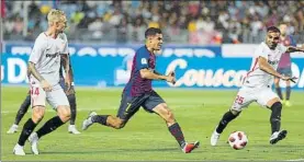  ?? FOTO: PEP MORATA ?? Coutinho trata de escapar de los defensas del Sevilla en la segunda mitad