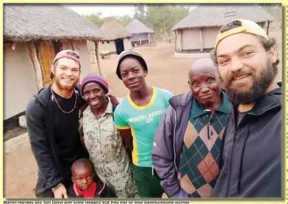  ??  ?? Warren Handley and Tom David with some villagers that they met on their adventures­ome journey