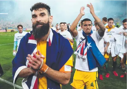  ?? MAN OF MOMENT: Mile Jedinak and Tim Cahill celebrate after defeating Honduras to win a place at the World Cup. ??
