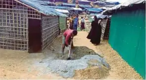  ??  ?? SUKARELAWA­N dalam kalangan pelarian Rohingya menyiapkan klinik di Kem Kutupalong.