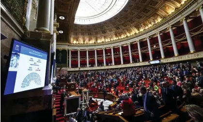  ?? Emmanuel Dunand/AFP/Getty Images ?? Almost all members of President Macron’s centrist minority coalition as well as leftwing lawmakers voted for the measure. Photograph: