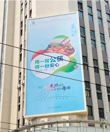 ??  ?? A billboard is designed to popularize serving chopsticks in Shanghai. — Andy Boreham