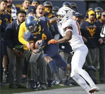  ?? Associated Press ?? West Virginia running back Leddie Brown picks up some of his 158 yards rushing Saturday before being knocked out of bounds by Texas defender Anthony Cook.