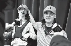  ?? Brad Nettles/The Post And Courier via AP ?? ■ Hanahan High School’s Cooper Dawson, right, talks to the media after first letting his friend and fellow senior Kingsley Feiman announce that he would play football at Syracuse University on early signing day Wednesday in Hanahan, S.C.