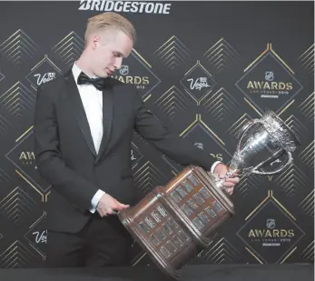  ?? AP PHOTO BY JOHN LOCHER ?? Vancouver Canucks’ Elias Pettersson looks at the Calder Memorial Trophy after winning the honour at the NHL Awards on Wednesday in Las Vegas.