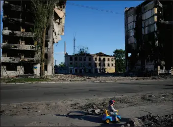  ?? Natacha Pisarenko The Associated Press ?? A boy plays in front of houses ruined by shelling on Tuesday in Borodyanka, Ukraine.