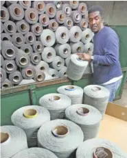  ?? STAFF FILE PHOTO ?? Jerry Burse inspects spools of yarn at the J&J Carpets plant in Dalton.