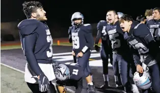  ?? LUKE E. MONTAVON/THE NEW MEXICAN ?? Capital’s Julian Sanchez, left, celebrates with teammates after they defeated Santa Fe High 28-0 on Friday at Jaguar Field. Capital won the district title and will be preparing for the playoffs next week.