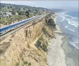  ?? AN AMTRAK John Gibbins The San Diego Union-Tribune ?? Surf liner train travels along the crumbling bluffs in Del Mar.