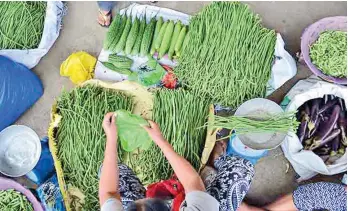  ?? ERWIN MASCARIÑAS ?? IN CAGAYAN DE ORO. A vendor prepares a plastic full of string beans for buyers at a roadside stand in Langihan, Butuan City.