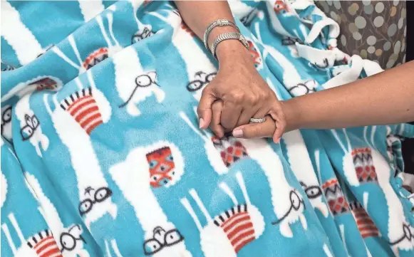  ??  ?? Maggie Spence, right, holds hands with her mom, Dorchelle, at West Cancer Center. Maggie Spence and her best friend, Naiya Nolan-Dillard, 17, raised $1,200 to buy 100 yards of material for 25 fleece blankets to give to chemothera­py patients. BRAD VEST/THE COMMERCIAL APPEAL