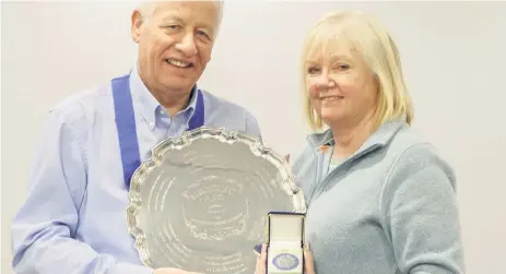  ??  ?? Plate trophy winners Joyce Manson received the trophy and medal for Strathaven Camera Club from SPF President John Mcvie