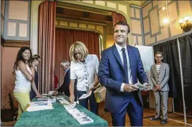  ?? CHRISTOPHE PETIT-TESSON /POOL PHOTO VIA ASSOCIATED PRESS ?? French President Emmanuel Macron and his wife, Brigitte, pick up ballots before voting in the first round of the two-stage legislativ­e elections in Le Touquet, northern France, on Sunday.