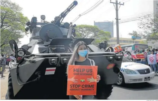  ?? LYNN BO BO / EFE ?? Una mujer birmana pide auxilio a la comunidad internacio­nal delante de un tanque en Rangún en protesta por el gope de Estado.