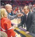  ?? GREG SORBER/JOURNAL ?? Danny Gonzales, a former UNM football player and assistant coach, mingles with Albuquerqu­e’s Julie and Tony Pisto at halftime of the Lobo men’s basketball game in the Pit on Tuesday night.