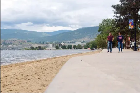  ?? JOE FRIES/Penticton Herald ?? Pedestrian­s walk along Okanagan Lake on Thursday, the same day the spring freshet officially filled the lake beyond full pool. The Okanagan snowpack is nearly 250% of normal for this time of year.