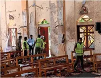  ?? Reuters ?? Police officers inspect the site of a bomb blast at St. Sebastian Catholic Church in Negambo on Monday. —