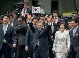  ??  ?? South Korea’s President Moon Jae-in (centre) with his wife Kim Jeong-suk as he waves to his supporters near the presidenti­al Blue House in Seoul on Wednesday. —
