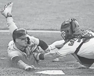  ?? DAVID RICHARD/USA TODAY SPORTS ?? Guardians catcher Cam Gallagher tags out Detroit Tigers shortstop Javier Baez in the third inning at Progressiv­e Field on Tuesday in Cleveland.