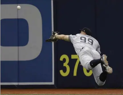  ?? CHRIS O’MEARA — ASSOCIATED PRESS ?? Aaron Judge makes a diving catch on a fly ball by Rays’ Evan Longoria during the sixth inning of Yankees victory on Sunday. Judge turned a double play against Rays’ Corey Dickerson.