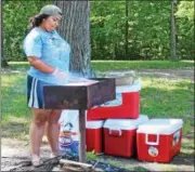  ?? TAWANA ROBERTS – THE NEWS-HERALD ?? Carmaletta Hinson, who works at Camp Burton, prepares lunch using the outdoor grills at Punderson State Park.