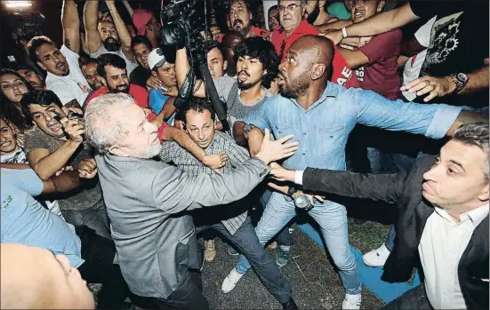  ?? SEBASTIAO MOREIRA / EFE ?? El expresiden­te brasileño Lula da Silva ayer en São Paulo, abriéndose paso entre la resistenci­a de sus seguidores para entregarse a la policía