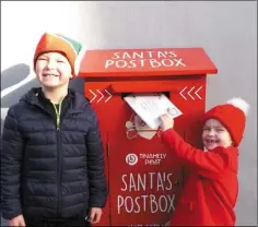  ??  ?? Milo and Lottie O’Toole post their letter to Santa Claus in the special red Santa post box in Tinahely.