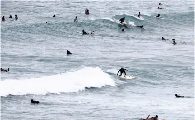  ?? PICTURE: AP ?? SETTLED WATERS: Surfers at Waikiki beach, Honolulu, ahead of Hurricane Lane.