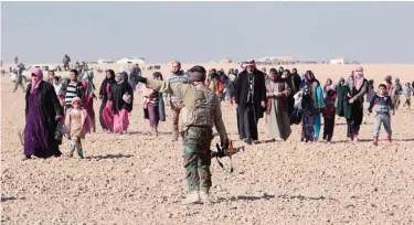  ??  ?? MOSUL: Iraqi families, who fled their homes in the Iraqi town Shwah west of Mosul due to the fighting between government forces’ and Islamic State (IS) group’s jihadists, are being escorted, from their makeshift camp to safer areas by Shiite fighters...