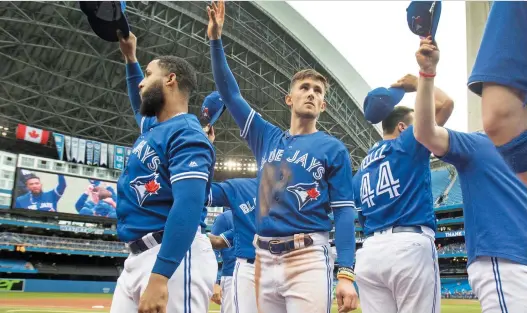  ?? THE CANADIAN PRESS/FILES ?? Blue Jays players tip their hats to fans during the final game of the season last September. There will be no fans in the stands if baseball resumes this summer.