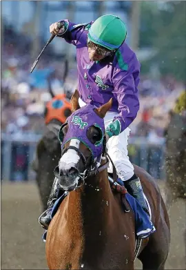  ?? THE ASSOCIATED PRESS — 2014 ?? Victor Espinoza celebrates aboard California Chrome after winning the 139th Preakness Stakes at Pimlico Race Course on May 17, 2014. The win set up a Triple Crown shot.