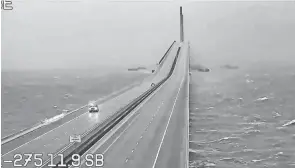  ?? FLDOT VIA AP ?? An emergency vehicle crosses the Sunshine Skyway over Tampa Bay, Fla., on Wednesday. Flash floods were possible across the whole state Wednesday as Hurricane Ian makes landfall, the hurricane center said. Florida Power and Light warned those in Ian’s path to brace for days without electricit­y.