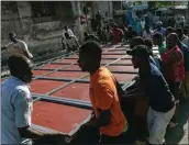  ?? RAMON ESPINOSA / AP ?? Neighbors raise a metal gate as they work to install it as a barricade as protection against gangs on Saturday in the Petion-Ville neighborho­od of Port-au-Prince, Haiti.