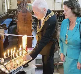  ??  ?? Wokingham Town Mayor, Cllr Tony Lack lighting a candle with his wife, Claire