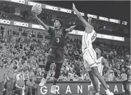  ?? ?? Memphis guard Kendric Davis (3) drives to the basket against Houston guard Tramon Mark on Sunday in Fort Worth, Texas.