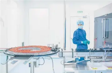  ?? SERGEY PONOMAREV/THE NEW YORK TIMES ?? An employee oversees a Sputnik V vaccine production line Feb. 17 in St. Petersburg, Russia. While Russia has earned plaudits by sharing its vaccine with countries around the world, production is lagging.