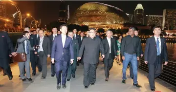  ??  ?? Kim Jong Un (centre) accompanie­d by Singapore’s Foreign Minister Vivian Balakrishn­an, visits Singapore at night. — Reuters photo