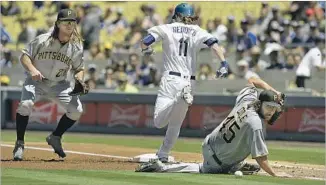  ?? Kevork Djansezian Getty Images ?? PIRATES STARTER Gerrit Cole looks for the baseball after he tried to catch a bunt single by the Dodgers’ Josh Reddick with teammate John Jaso covering first base.