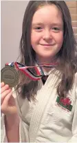  ??  ?? Paige, 11, with her medal