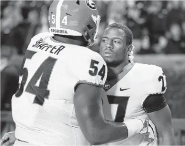  ?? CURTIS COMPTON/ASSOCIATED PRESS ?? Georgia lineman Justin Shaffer gives tailback Nick Chubb a hug on the sideline as time expires after the team’s 40-17 loss to Auburn. Auburn held Chubb, Sony Michel and the SEC’s top ground game to 46 yards.